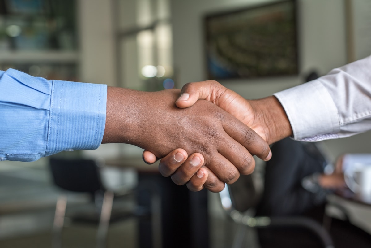 Two colleagues shaking hands after agreeing on payroll and HR support